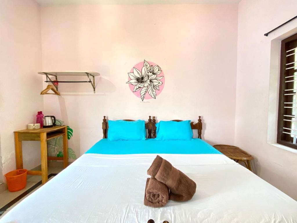 1 dormitorio con 1 cama con toallas en Mango Villa, en Varkala