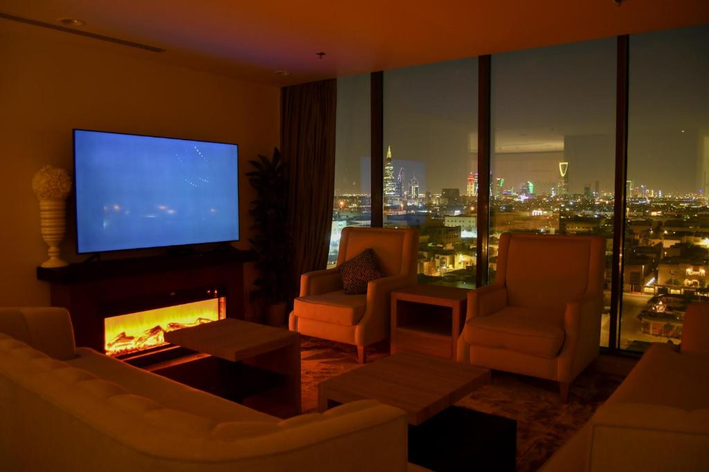uma sala de estar com televisão e lareira com vista em Stylish and private apartment em Riyadh