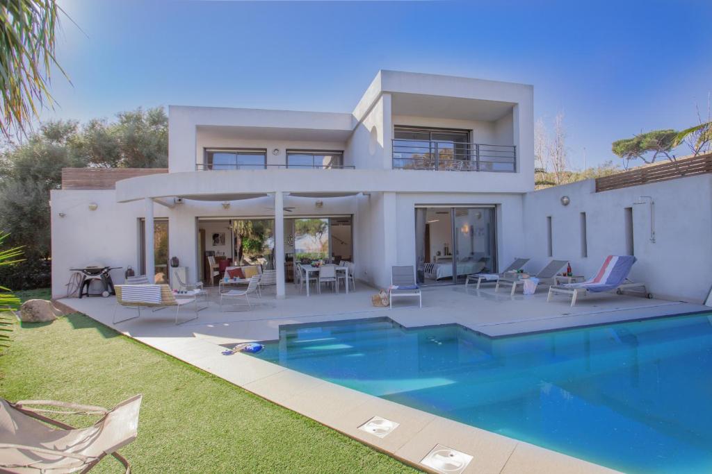 uma casa com uma piscina em frente em Villa U Spanu em Lumio