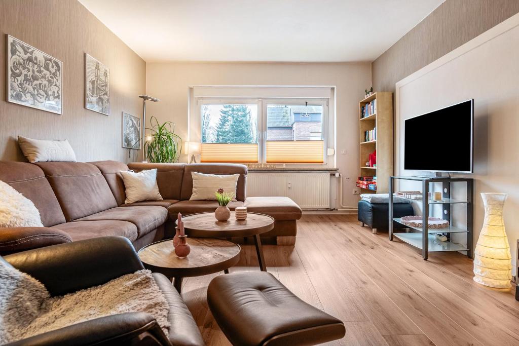 ein Wohnzimmer mit einem Sofa und einem TV in der Unterkunft Ferienwohnung Glückauf in Castrop-Rauxel