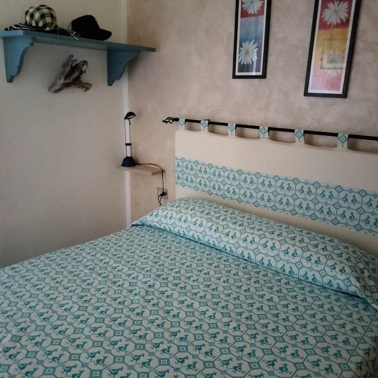 1 dormitorio con 1 cama con edredón azul en PM 22 Via Cala Sabina Guest House, en Stintino