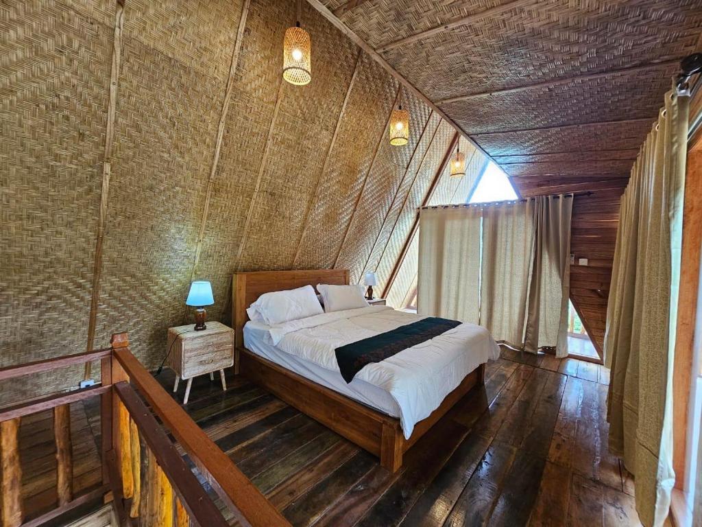 1 dormitorio con 1 cama en una habitación de madera en UmaUthu Bali, en Tabanan