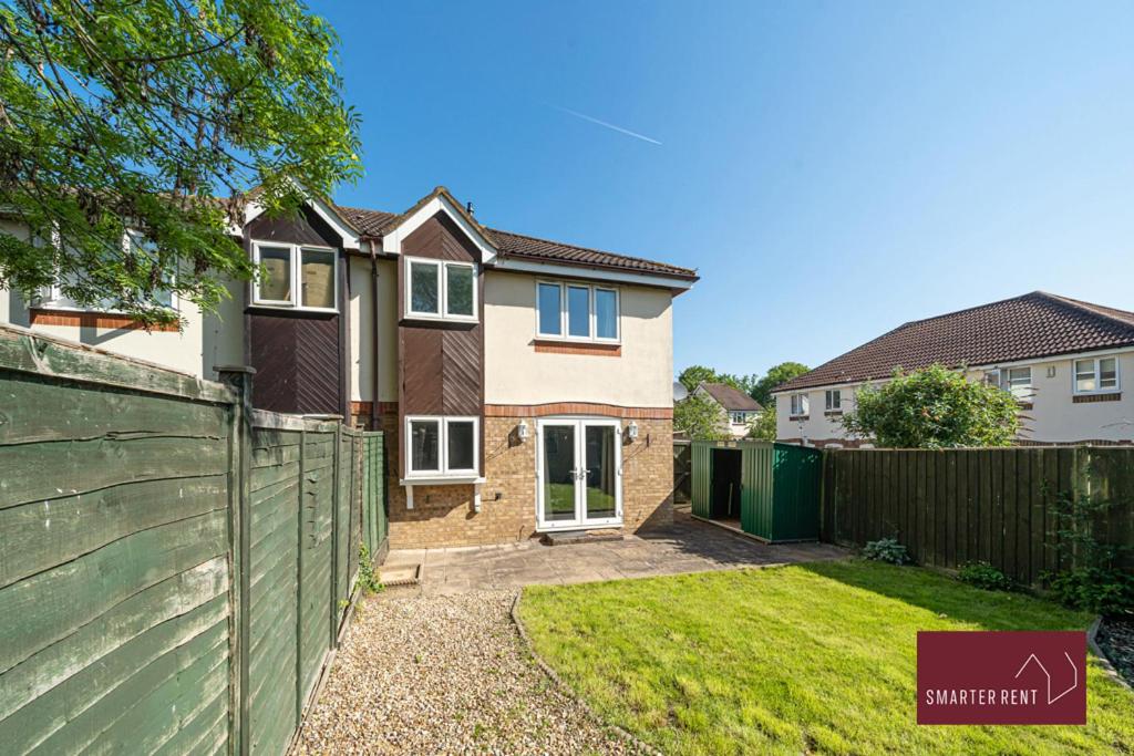 a house with a fence in a yard at Bracknell - 1 Bedroom House - Garden and Parking in Binfield