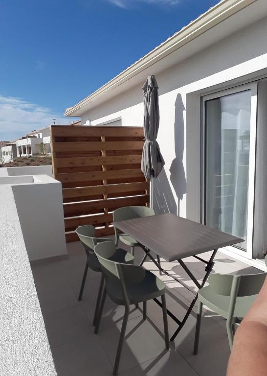 un patio avec une table, des chaises et un parasol dans l'établissement T2 VUE MER MARINA DI BRAVONE N197, à Linguizzetta