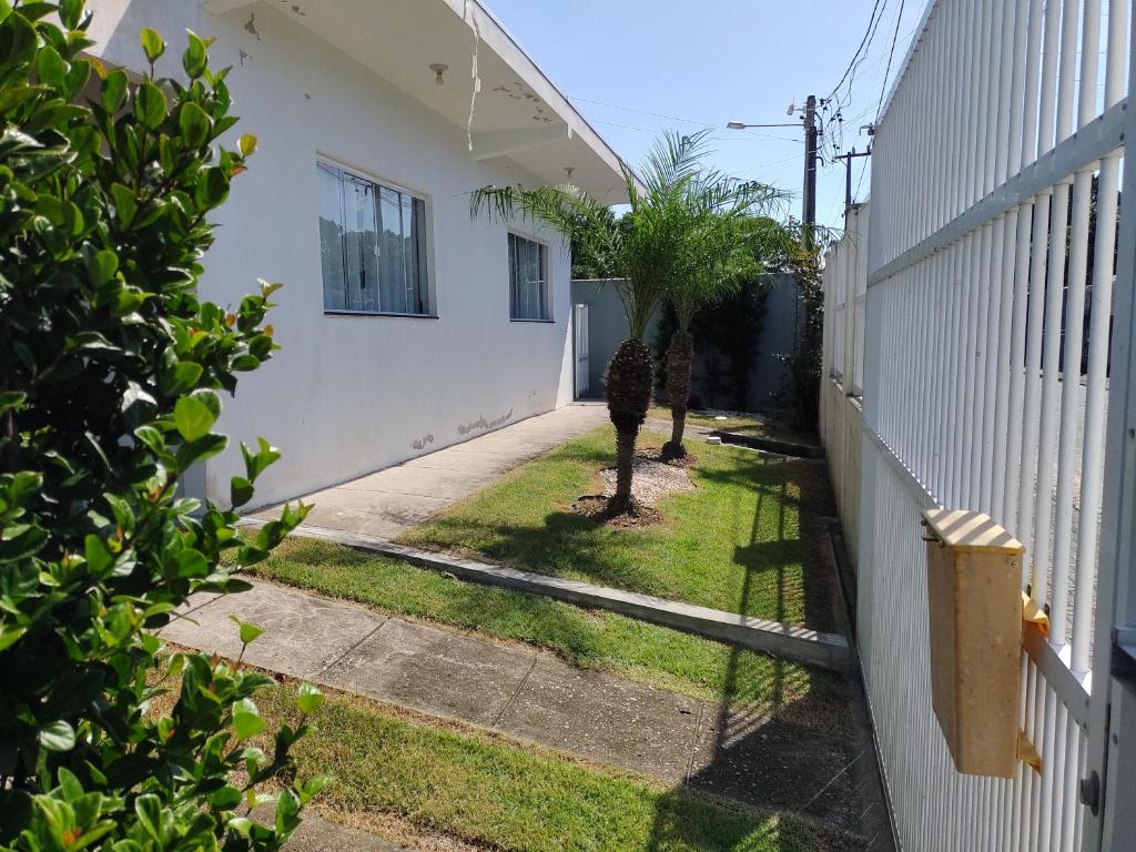 an empty yard next to a house with a fence at Linda Casa Jardim - 500 Mts da Praia in Navegantes