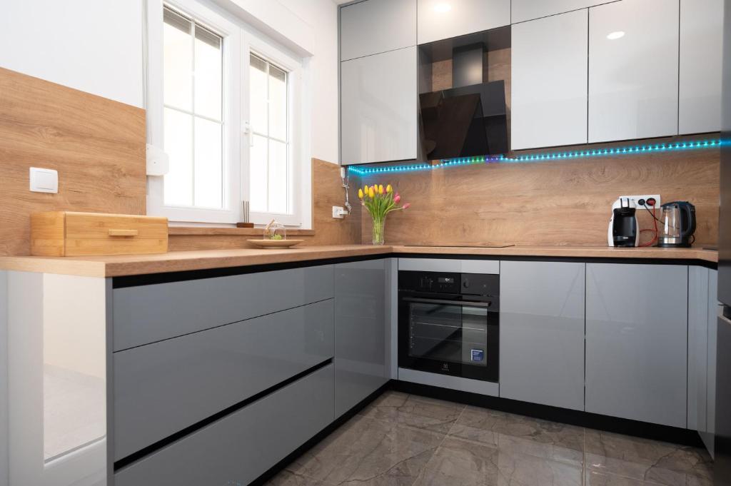 a kitchen with white cabinets and a wooden counter top at Apartment MM in Sukošan