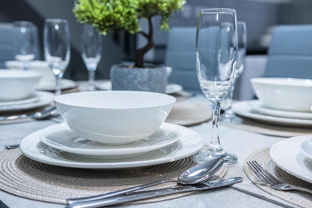 a table with a bowl and plates and wine glasses at Impeccable 4-Bed House in Telford West Midlands in Telford