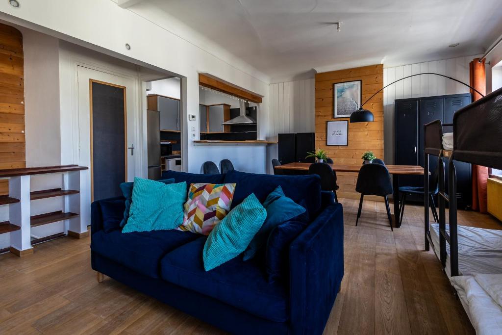 uma sala de estar com um sofá azul e uma cozinha em L Etoile de Boulogne proche plage et nausicaa em Boulogne-sur-Mer