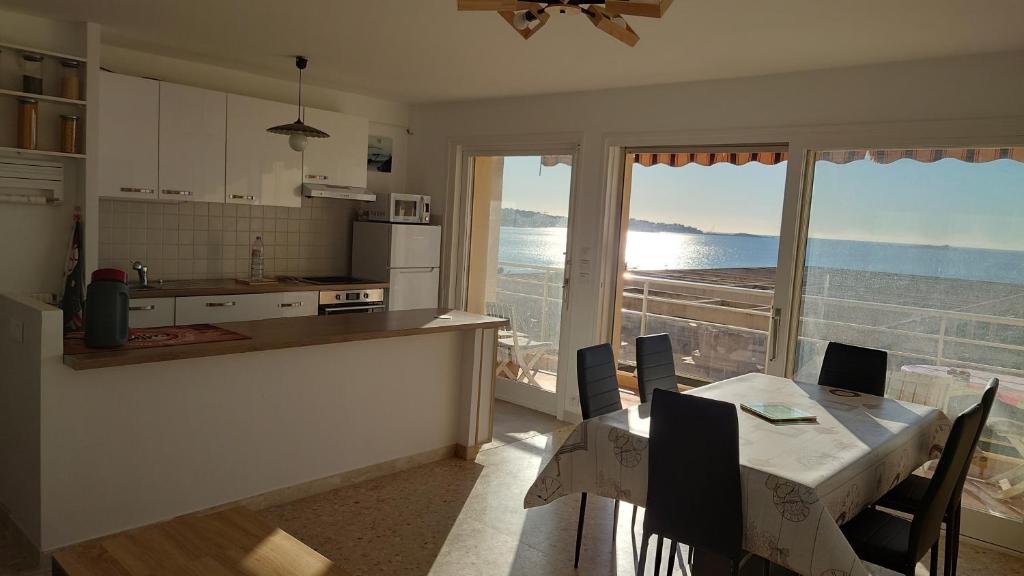a kitchen with a table and a view of the ocean at Appartement vue mer 80m2 in Fréjus