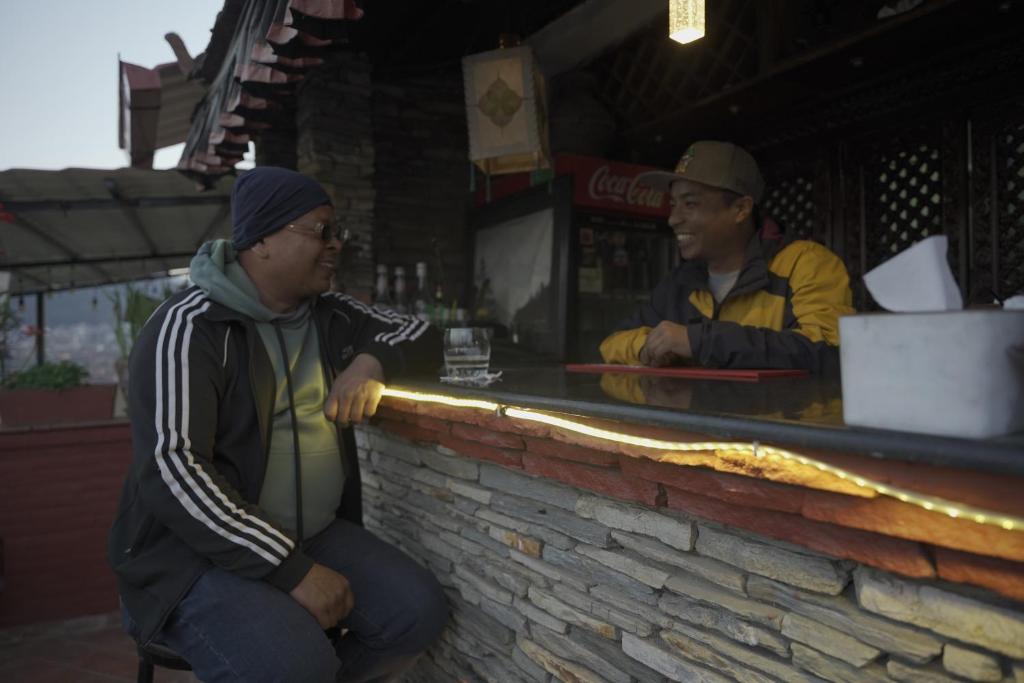 two men sitting at a bar in front at Cosy Hotel in Bhaktapur