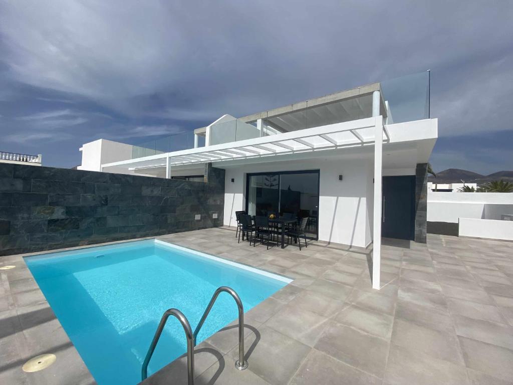 eine Villa mit Swimmingpool und ein Haus in der Unterkunft Aguja, Villa con piscina y barbacoa para disfrutar in Puerto Calero