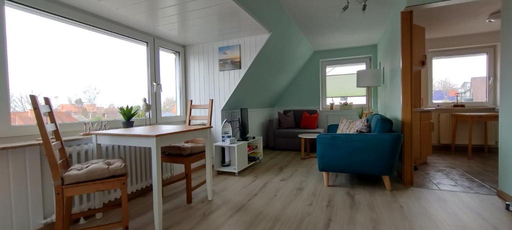 a living room with a blue chair and a couch at Schippkieker in Heikendorf