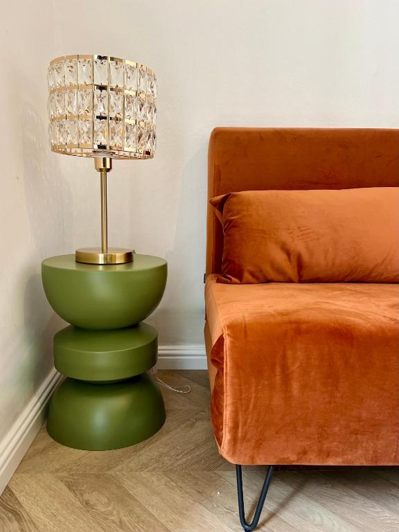 une lampe assise au-dessus d'une table verte à côté d'un canapé dans l'établissement Studio hyper centre, à Ajaccio