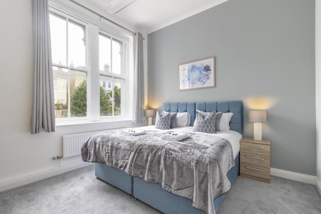 um quarto com uma cama azul e uma janela em OPP Plymouth - Large 3 bed, great WIFI and parking! BIG SAVINGS booking 7 nights or longer! em Plymouth