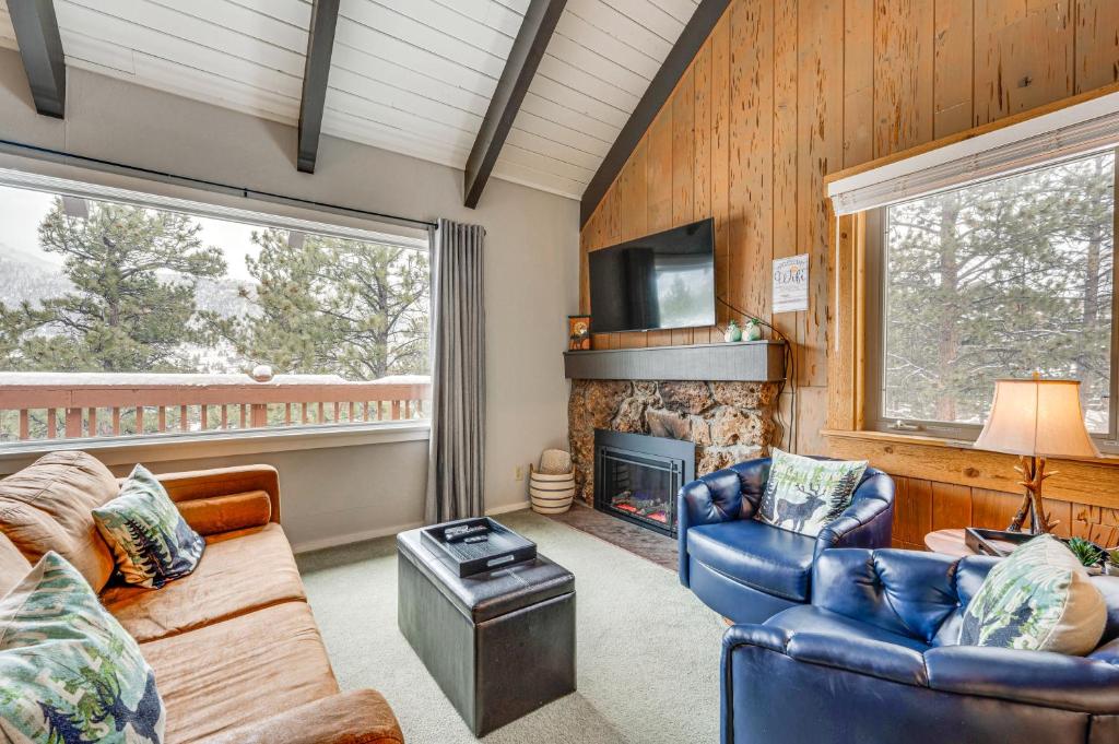 a living room with a couch and a fireplace at Cozy Estes Park Condo with Balcony and Fireplace! in Estes Park