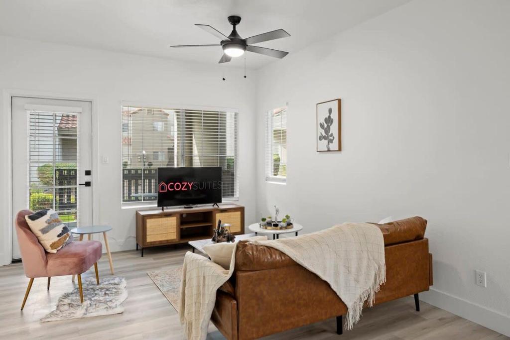 ein Wohnzimmer mit einem Sofa und einem TV in der Unterkunft CozySuites TPC Scottsdale with parking, pool in Scottsdale
