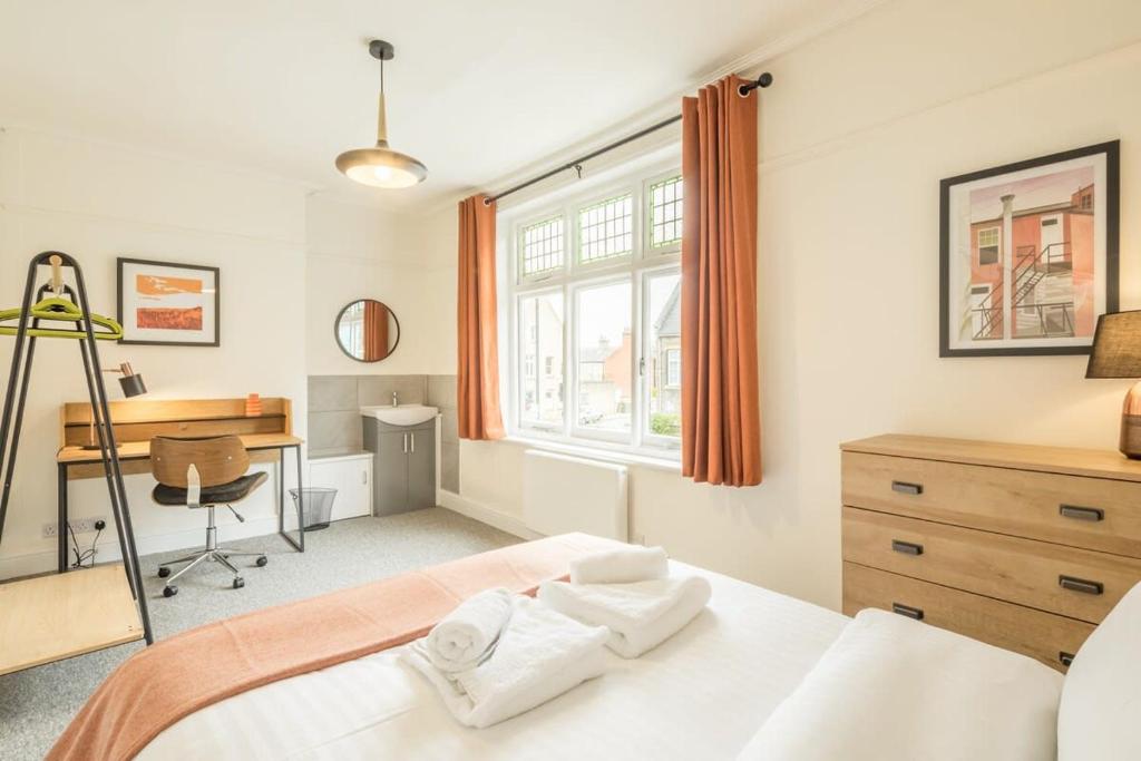 Schlafzimmer mit einem Bett, einem Schreibtisch und einem Fenster in der Unterkunft Fabulous Large Apartment for 7 - CENTRAL Cambridge in Cambridge