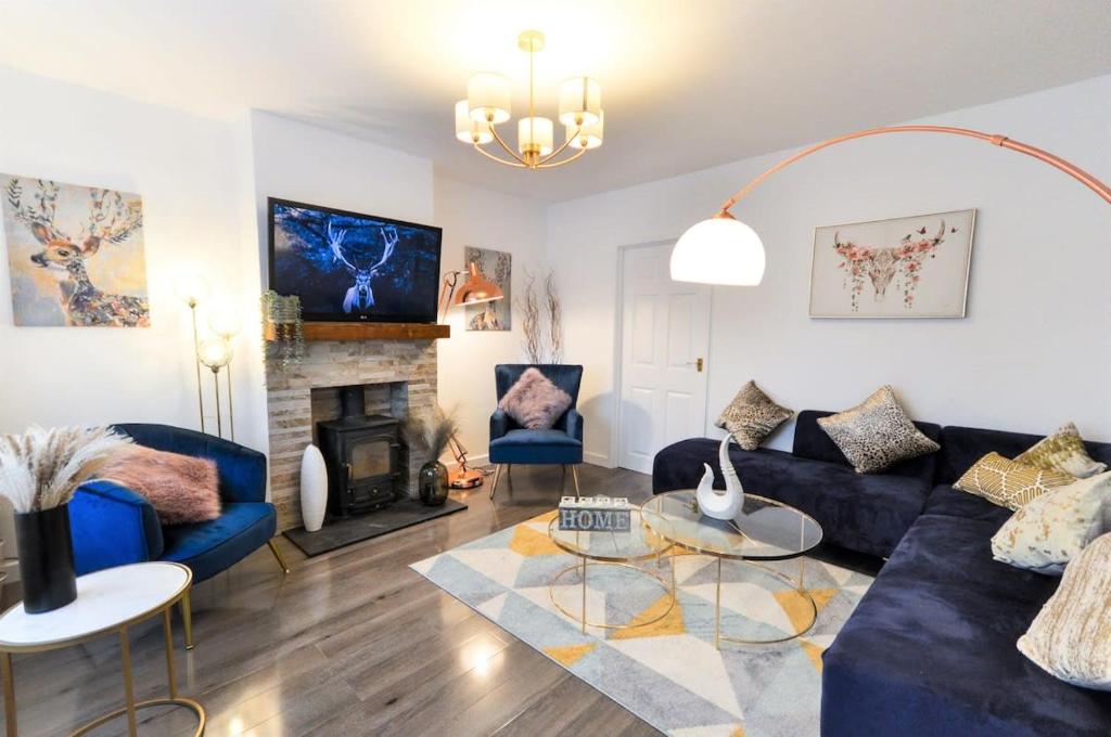 a living room with blue couches and a fireplace at Rest on Super-King Bed under The Starry Night in Chesterton