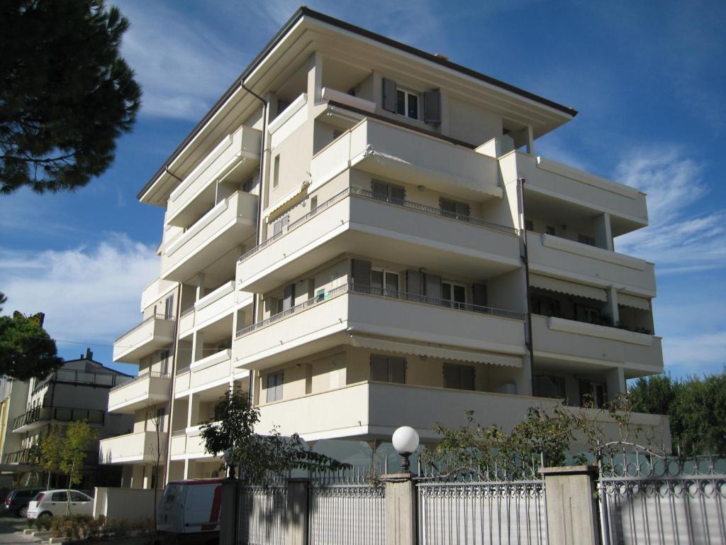 a white building with a fence in front of it at Residence Alba in Riccione