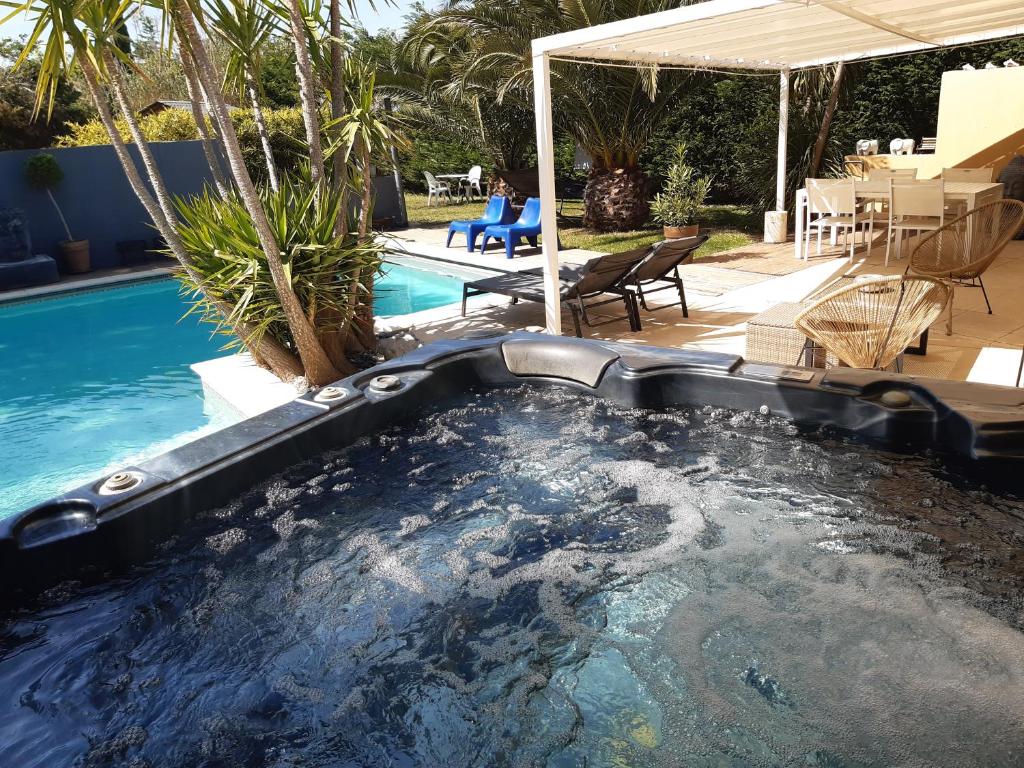 a swimming pool with a hot tub in a backyard at la villa des amoureux spa in Sorgues