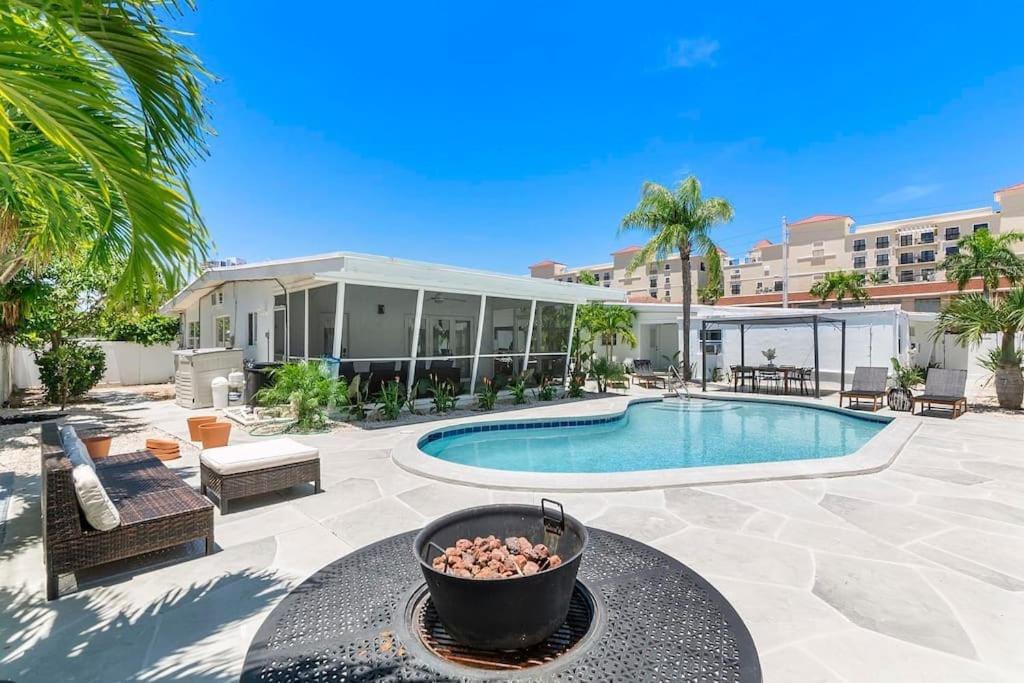 un patio con piscina y un edificio en Coconut Walk To The BeachComfy Beds Firepit Pool en Fort Lauderdale