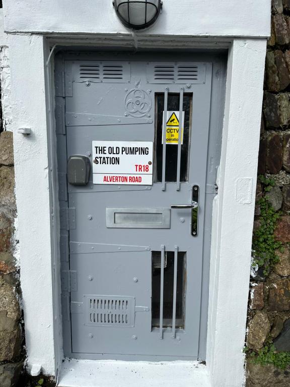 drzwi z znakami w budynku w obiekcie The old water pumping station quirky underground hobbit house w mieście Penzance