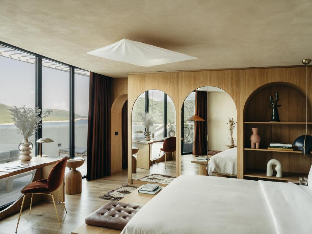 a bedroom with a large bed and a desk and chairs at Mamula Island in Žanjica