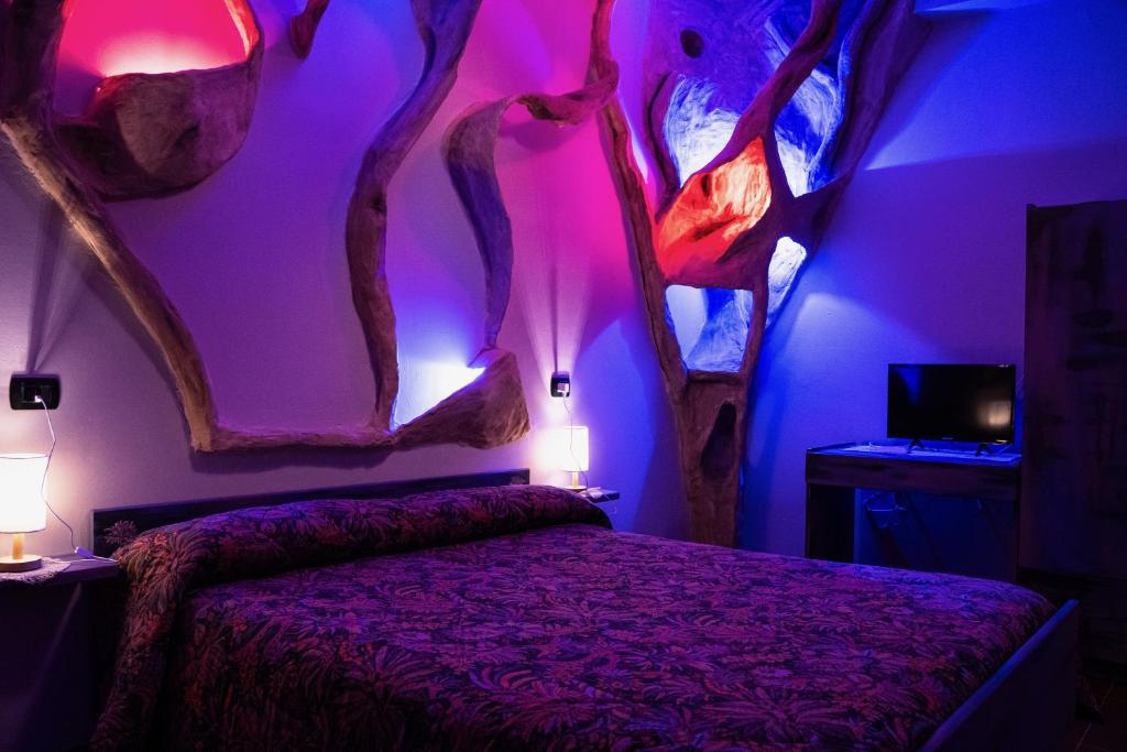 una camera con un letto in una stanza con alberi sul muro di HOTEL 1+1 di C.Costabile & f.lli a Pontecagnano