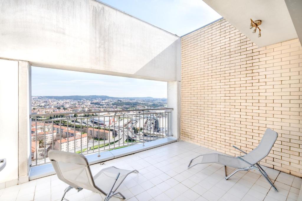 Zimmer mit 2 Stühlen und einem großen Fenster in der Unterkunft VIVA Stadium Residence Studios in Porto