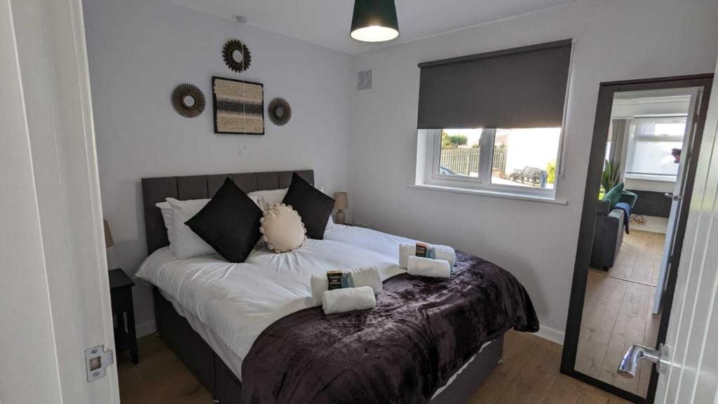 um quarto com uma cama com lençóis brancos e uma janela em OPP Sidmouth - Cosy Coastal Chalet great views! BIG SAVINGS booking 7 days or more! - Dogs by Request Only em Sidmouth
