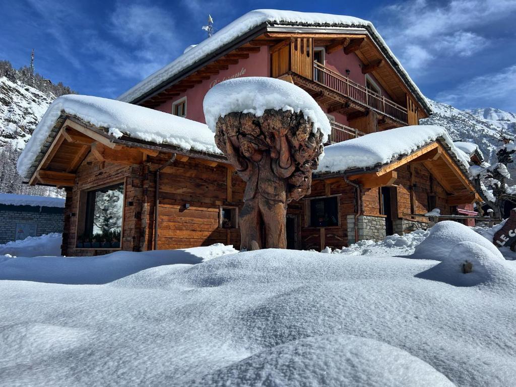 ein Blockhaus mit Schnee auf dem Boden davor in der Unterkunft HIBOU Chambres Affittacamere Cogne in Cogne