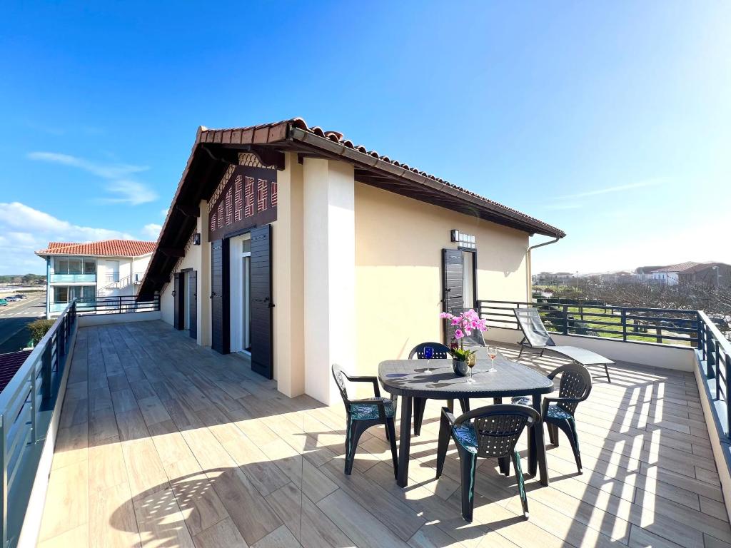un patio avec une table et des chaises sur un balcon dans l'établissement Ô COURANT - T3 terrasse vue océan, à Mimizan