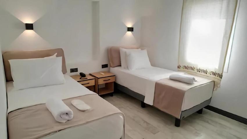 um quarto de hotel com duas camas e uma mesa em The Professor's Hotel em Bodrum City