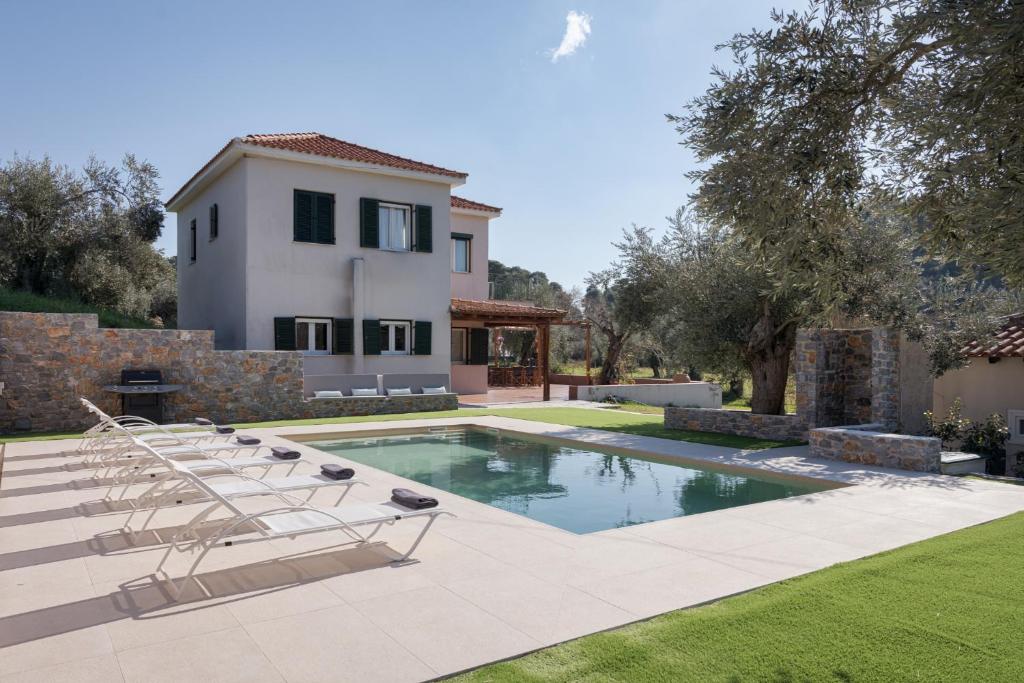 a house with a swimming pool with lounge chairs at Nature Retreat Skiathos Villa in Kolios