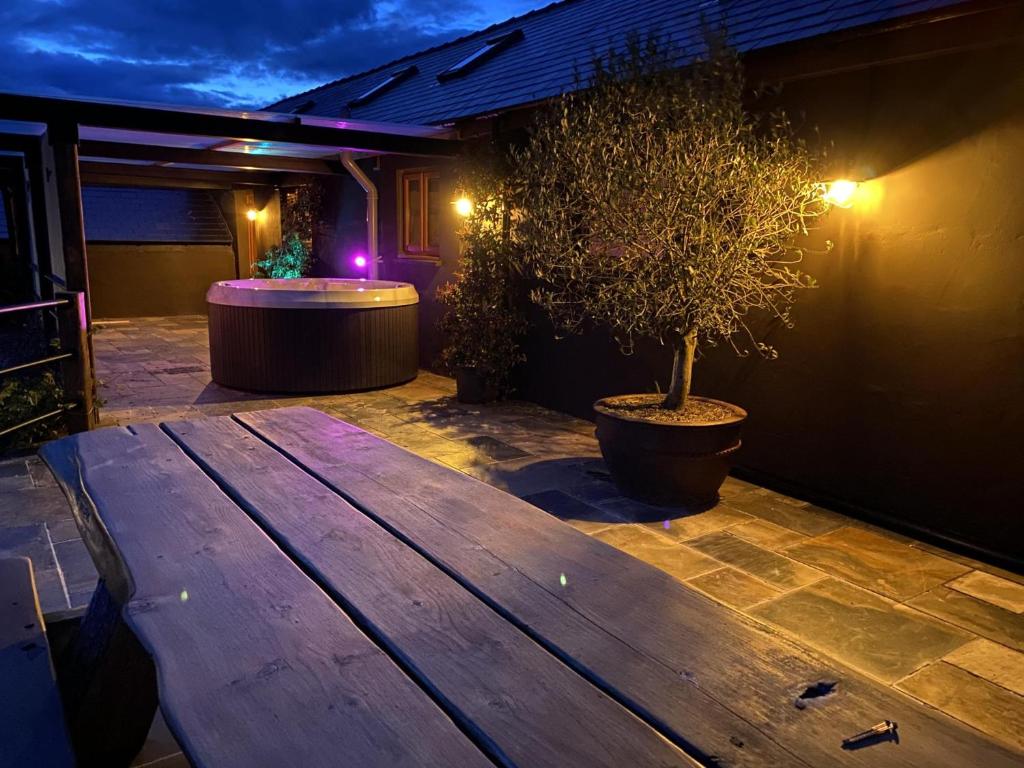 una mesa de madera en un patio con una maceta en Lavender - Luxurious Barn Conversion - Blossom Farm, en Johnston