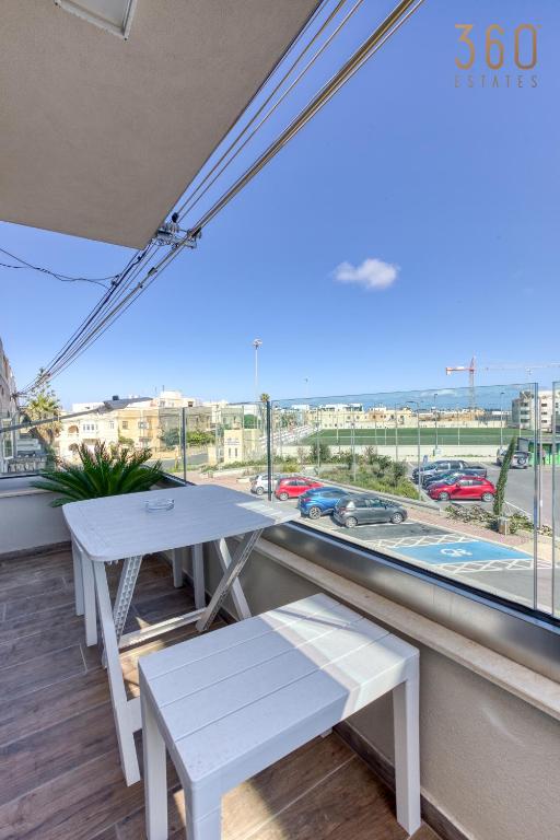 a balcony with two white benches and a large window at Bright &amp; cosy 3BR home with private balcony &amp; WIFI by 360 Estates in Dingli