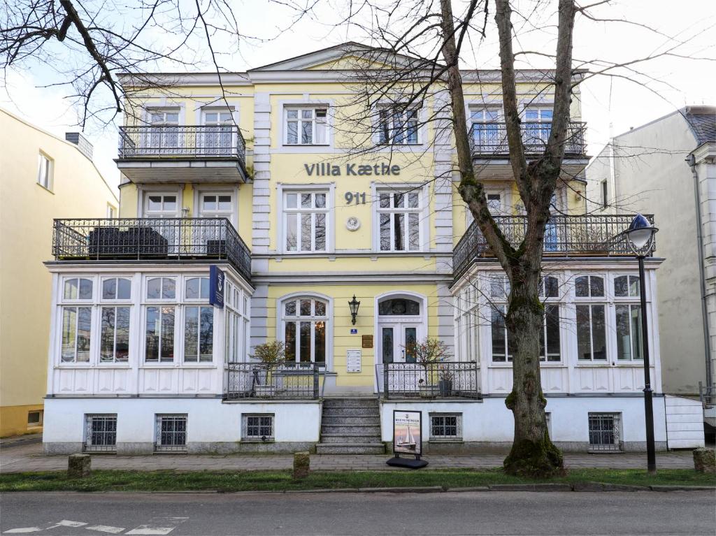 ein gelbes und weißes Gebäude mit einer Treppe davor in der Unterkunft Apartment im Souterrain in Rostock