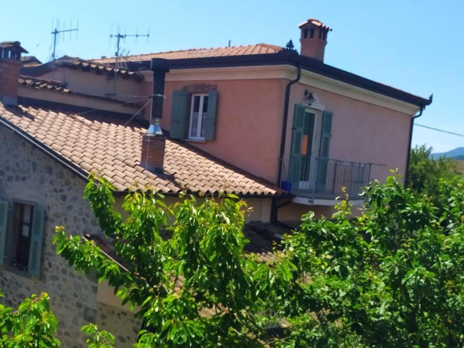 a house with a roof with trees in the foreground at Casa Vacanza Nonna Lida in Villafranca in Lunigiana