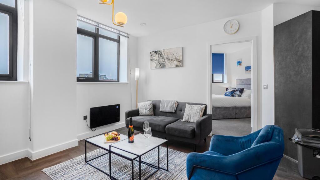 een woonkamer met een bank en een tafel bij Priority Suite - Modern 2 Bedroom Apartment in Birmingham City Centre - Perfect for Family, Business and Leisure Stays by Estate Experts in Birmingham