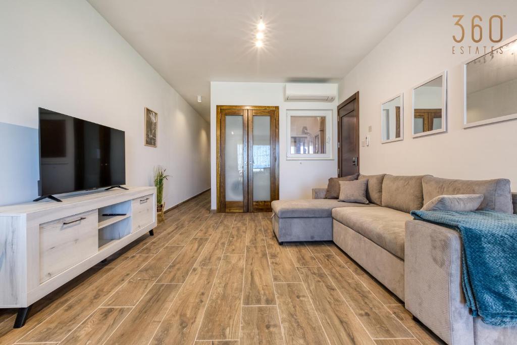 a living room with a couch and a flat screen tv at Bright &amp; cosy 3BR home with private balcony &amp; WIFI by 360 Estates in Dingli