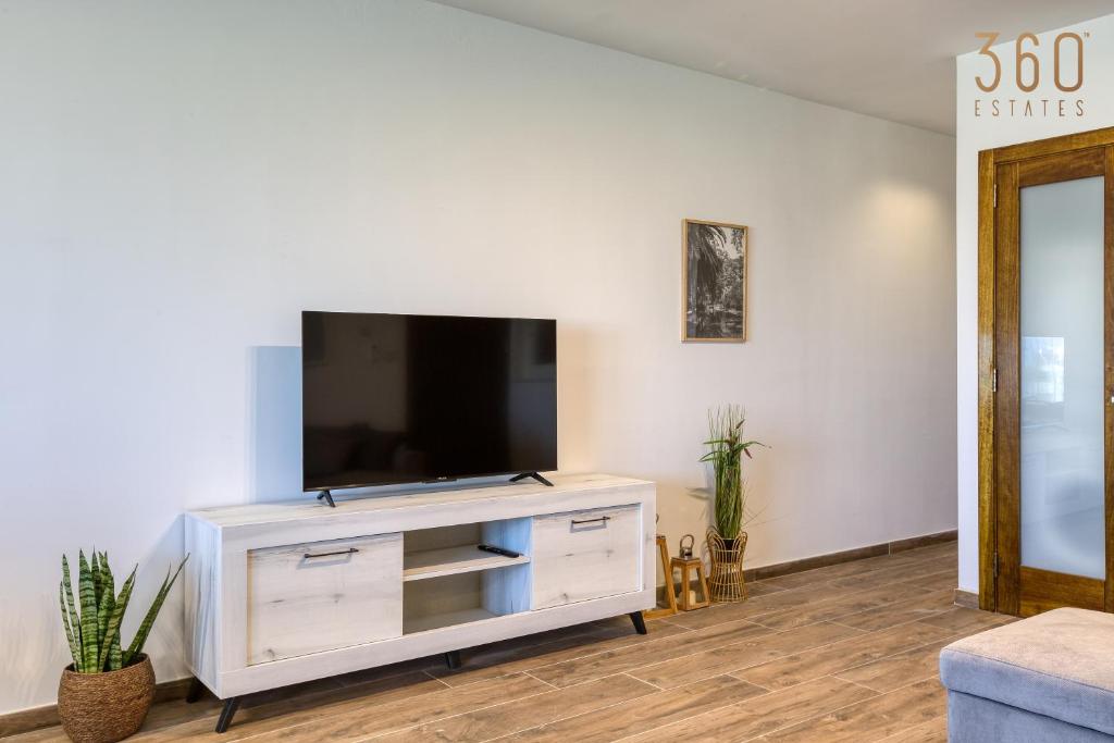 a living room with a flat screen tv on a white cabinet at Bright &amp; cosy 3BR home with private balcony &amp; WIFI by 360 Estates in Dingli