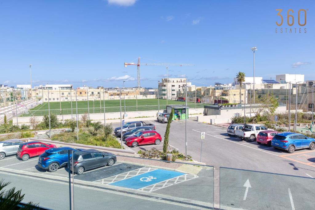 a parking lot with many cars parked in it at Bright &amp; cosy 3BR home with private balcony &amp; WIFI by 360 Estates in Dingli