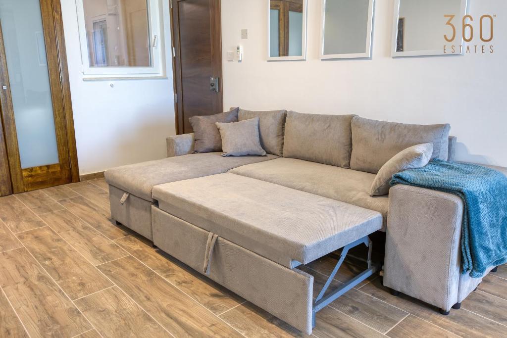 a living room with a couch and a table at Bright &amp; cosy 3BR home with private balcony &amp; WIFI by 360 Estates in Dingli