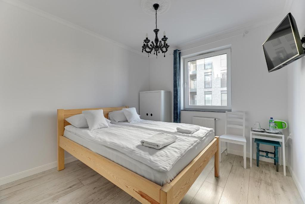a bedroom with a bed and a window at Grobla Centrum 1 by Grand Apartments in Gdańsk