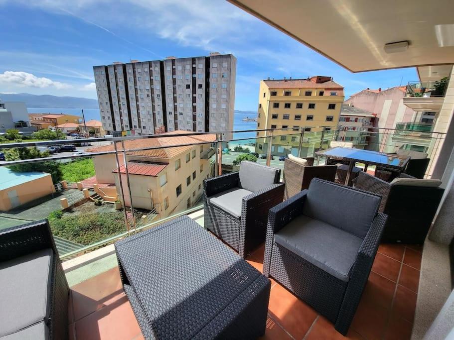 - un balcon avec des chaises et des tables dans un bâtiment dans l'établissement Apartment with direct access to the beach(WIFI), à Sanxenxo