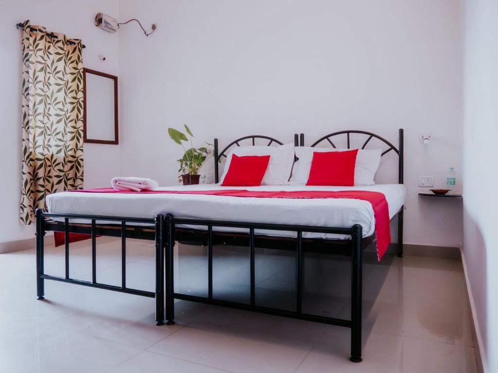 een slaapkamer met een groot bed met rode kussens bij C9 Anjuna in Anjuna