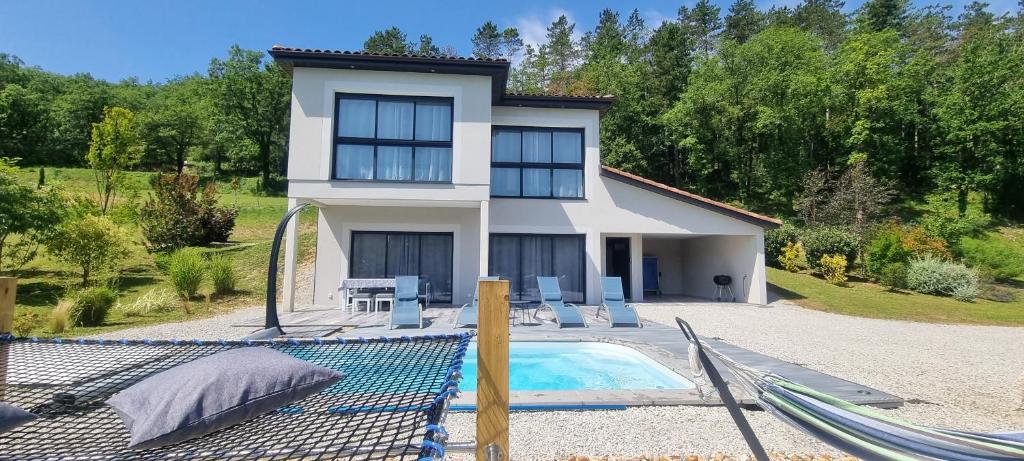 una casa con piscina frente a una casa en Gîtes Veyrières, en Concorès