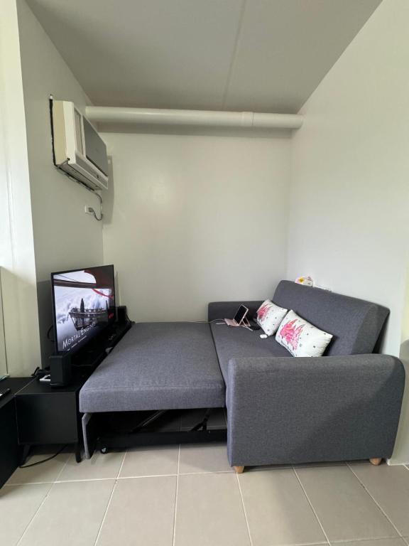 ein Wohnzimmer mit einem Sofa und einem Flachbild-TV in der Unterkunft Near Mactan Airport and Indiana Aerospace University, Lapu Lapu City in Pajak