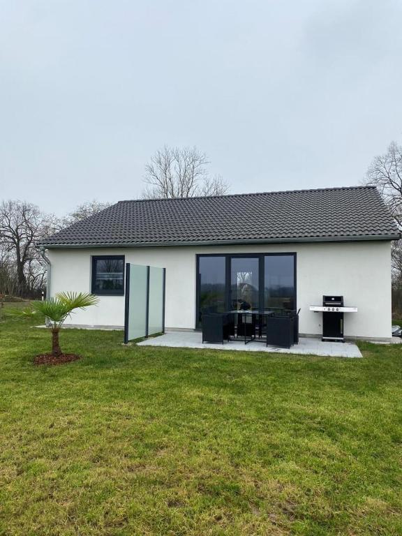 a white house with a table in a yard at NEU! Modernes Ferienhaus Schwanbeck in Dassow