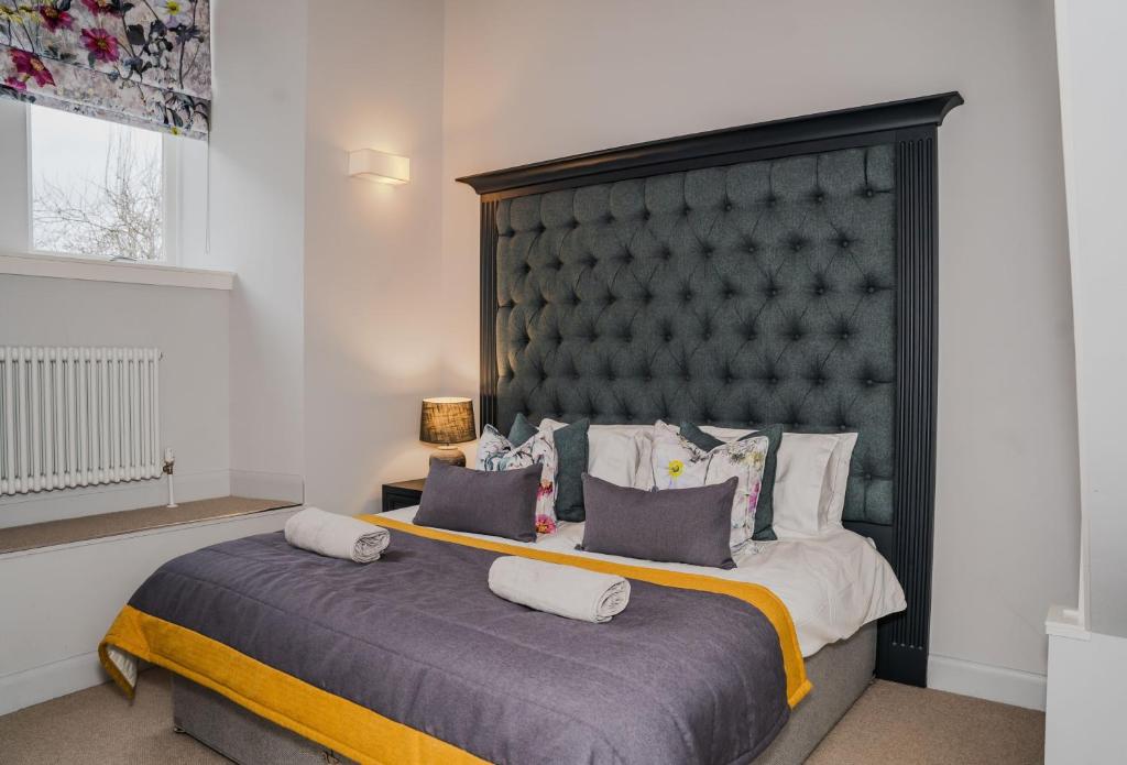 1 dormitorio con 1 cama grande y cabecero grande en The Kinross Residence en Kinross